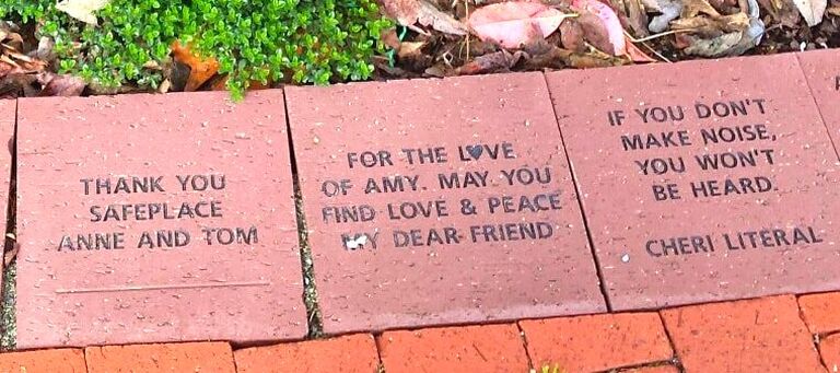 Picture of square terra cotta colored brick pavers, with script saying 